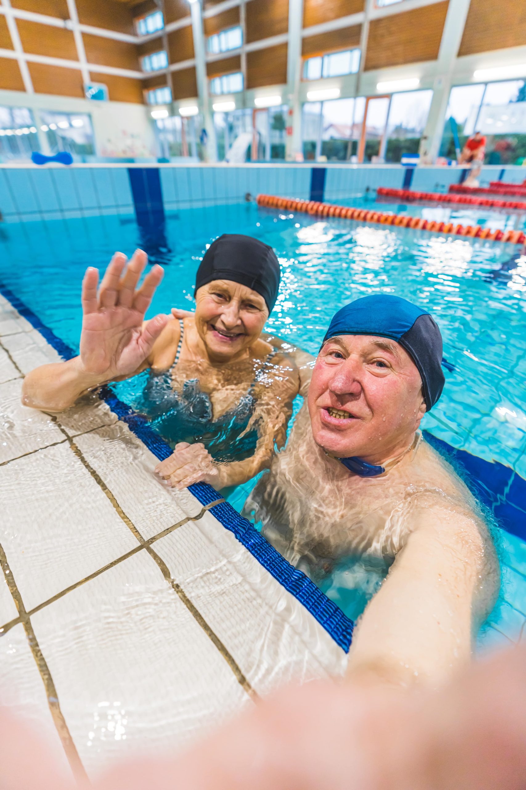 Starsza para robi selfie w krytym basenie – atmosfera zajęć dla dorosłych Fast Swim